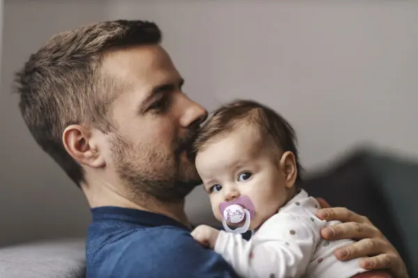 Een vader die zijn baby knuffelt.